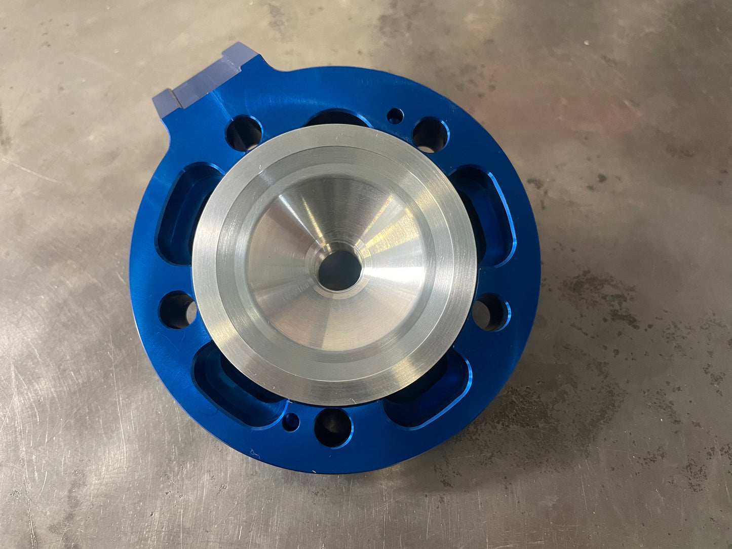 A blue and aluminum Yamaha Athena YZ125 big bore cylinder head.